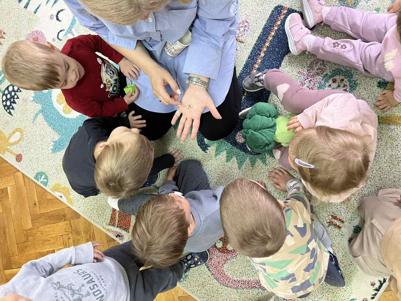 Vaspitačica sa decom u krugu na tepihu, jutarnja okupljanja u Vrtiću Kornjačica.